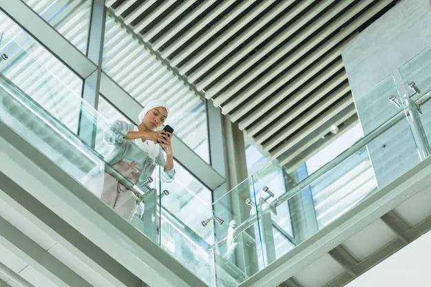 [freepicdownloader.com] businesswoman hijab leaning railing using mobile phone corridor modern office normal 13 11zon